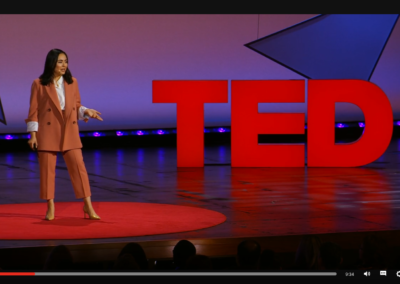 Zrzut ekranu z TED - prelegentka w łososiowym kostiumie i szpilkach